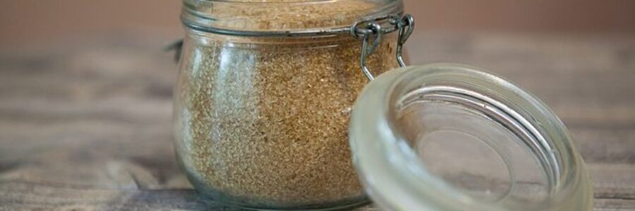 Glass jar of raw sugar - exfoliating skin naturally