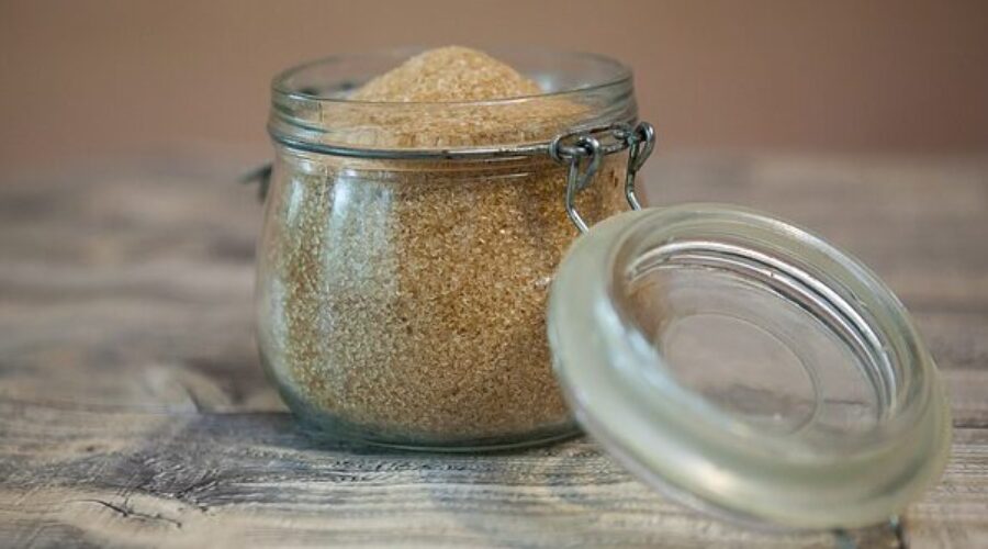 Glass jar of raw sugar - exfoliating skin naturally
