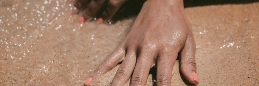 Woman's hands in the sand - natural sun protection skin health