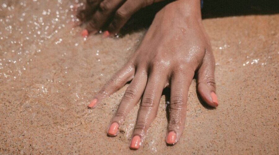 Woman's hands in the sand - natural sun protection skin health