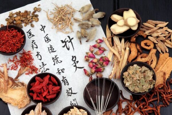 Herbs in small bowls on scroll with Chinese script - oriental medicine dermatology